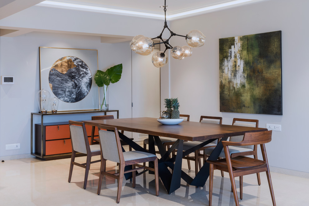 This is an example of a mid-sized contemporary separate dining room in Mumbai with beige floor and grey walls.