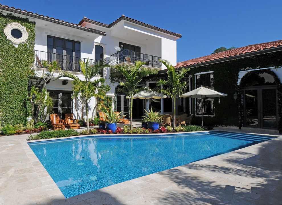 This is an example of a large mediterranean courtyard custom-shaped lap pool in Miami with tile.