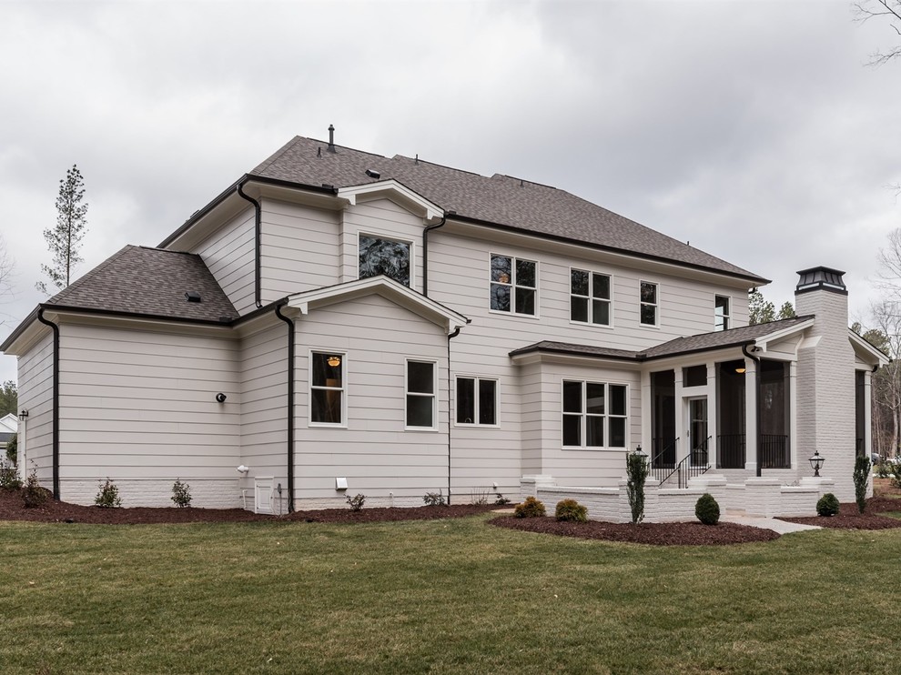 Example of a classic gray two-story concrete fiberboard house exterior design in Raleigh with a hip roof and a shingle roof