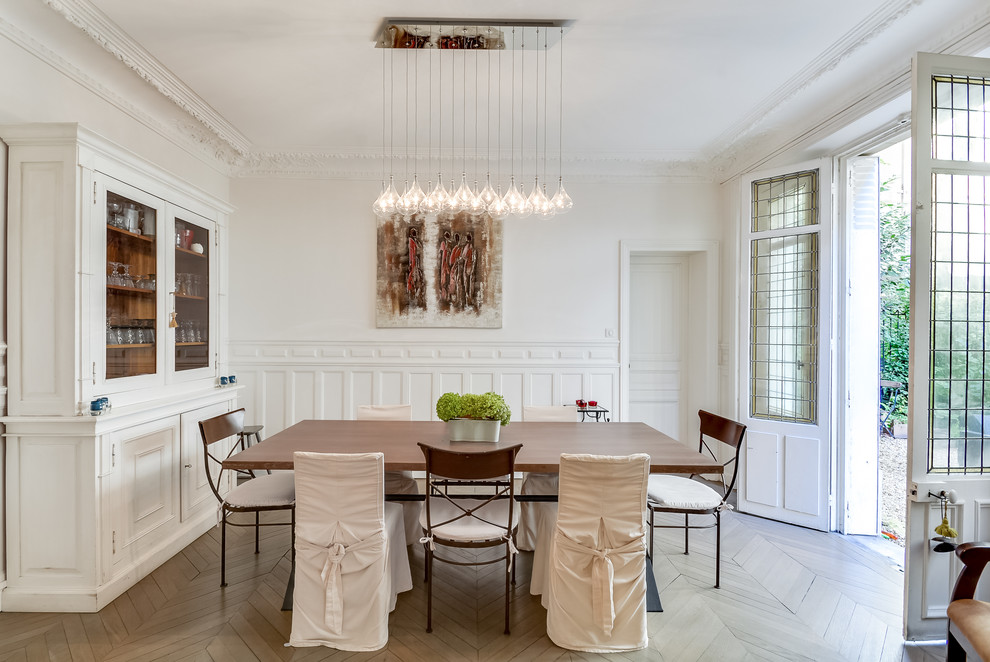 Large transitional separate dining room in Paris with white walls, no fireplace and painted wood floors.