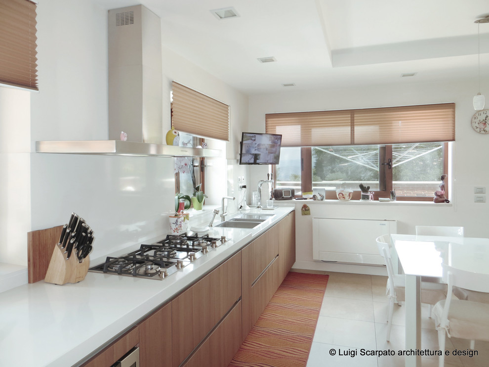 This is an example of a large modern single-wall separate kitchen in Naples with a double-bowl sink, flat-panel cabinets, medium wood cabinets, quartzite benchtops, white splashback, stainless steel appliances, porcelain floors, no island and beige floor.