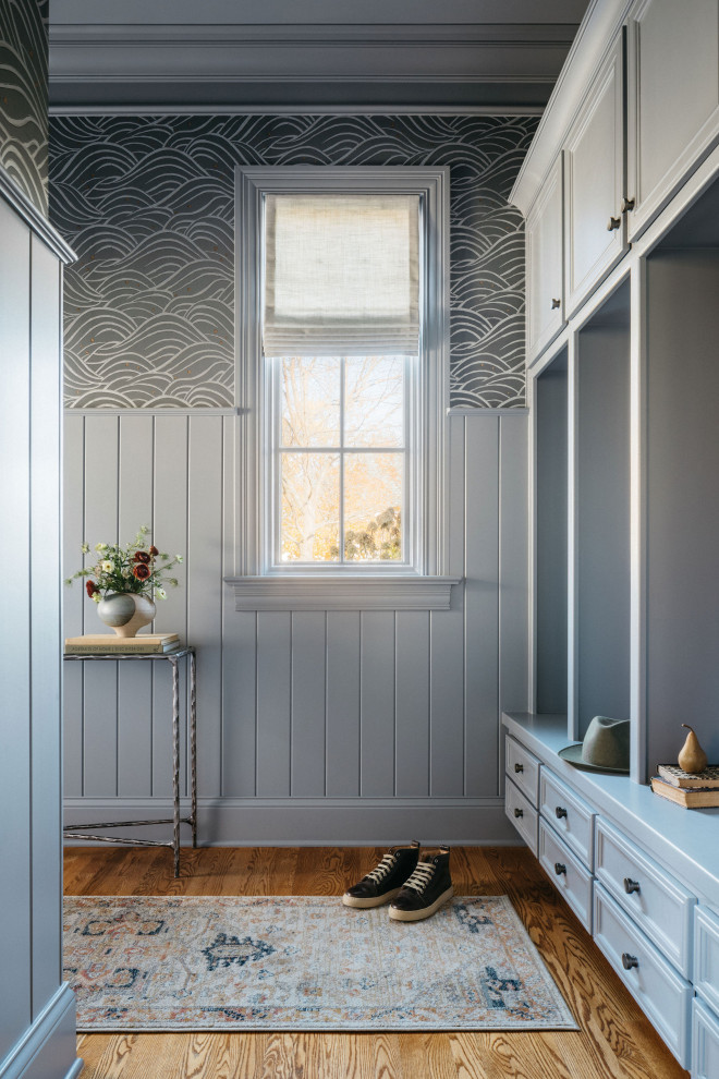Esempio di un ingresso con anticamera minimalista di medie dimensioni con pareti blu, pavimento in legno massello medio, pavimento marrone e carta da parati