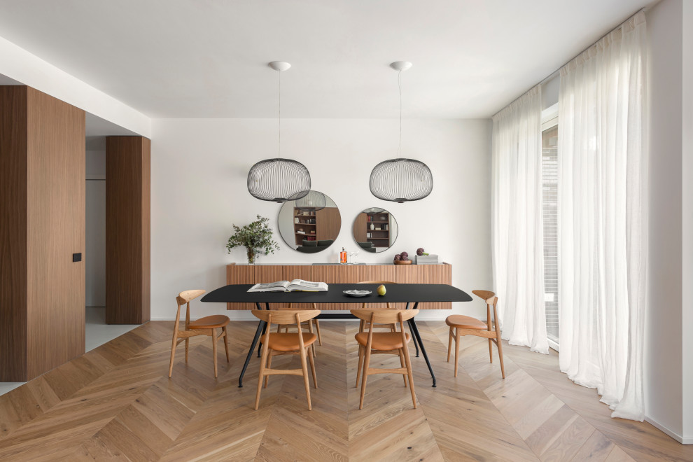 Ejemplo de comedor minimalista grande abierto con paredes blancas, suelo de madera en tonos medios y panelado