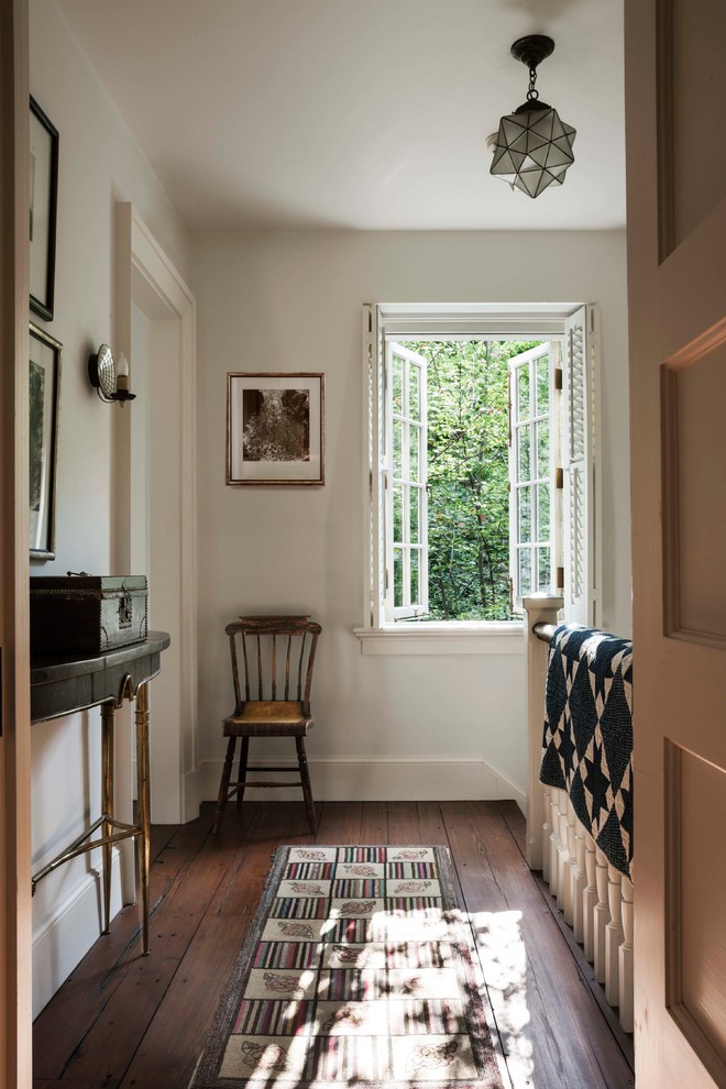 Inspiration for a traditional hallway in New York with white walls and dark hardwood floors.