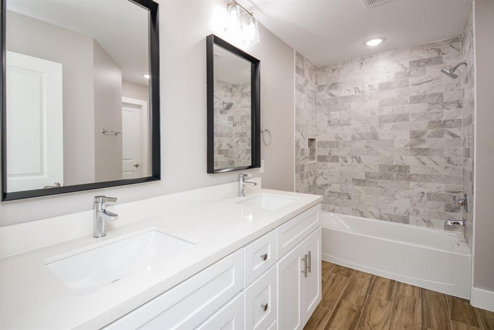 Inredning av ett modernt mellanstort vit vitt badrum för barn, med vita skåp, en öppen dusch, en toalettstol med hel cisternkåpa, svart kakel, porslinskakel, vita väggar, ett undermonterad handfat, marmorbänkskiva, grått golv, med dusch som är öppen och skåp i shakerstil