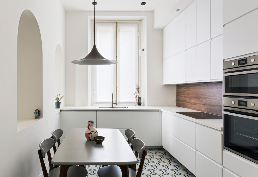 Inspiration for a mid-sized contemporary l-shaped kitchen in Milan with white cabinets, cement tiles, white benchtop, an undermount sink, flat-panel cabinets, brown splashback, timber splashback, panelled appliances, no island and multi-coloured floor.
