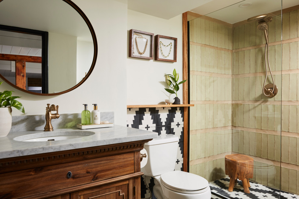 Photo of a mid-sized transitional 3/4 bathroom in Minneapolis with recessed-panel cabinets, brown cabinets, an open shower, a two-piece toilet, green tile, glass tile, white walls, an integrated sink, marble benchtops, an open shower, grey benchtops, a single vanity, a freestanding vanity, ceramic floors and multi-coloured floor.