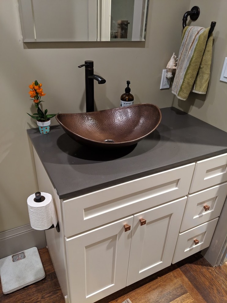 Photo of a small arts and crafts bathroom in San Francisco with shaker cabinets, white cabinets, an alcove tub, a shower/bathtub combo, a two-piece toilet, multi-coloured tile, ceramic tile, green walls, dark hardwood floors, a vessel sink, granite benchtops, brown floor, a sliding shower screen and grey benchtops.