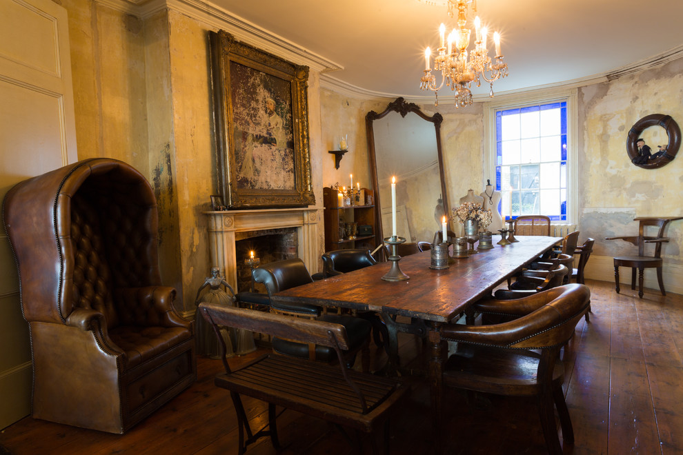 Photo of a mid-sized traditional separate dining room in London with dark hardwood floors, a standard fireplace and a plaster fireplace surround.