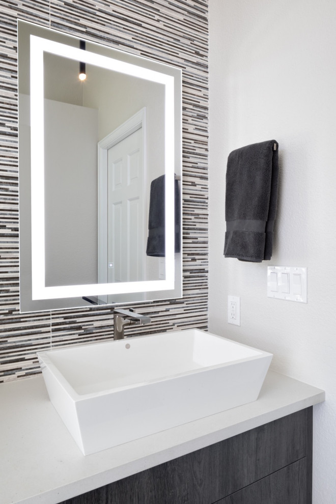 This is an example of a large contemporary ensuite bathroom in Denver with flat-panel cabinets, white cabinets, a freestanding bath, a walk-in shower, multi-coloured tiles, white walls, slate flooring, a vessel sink, quartz worktops, grey floors, a hinged door, white worktops, a single sink and a built in vanity unit.