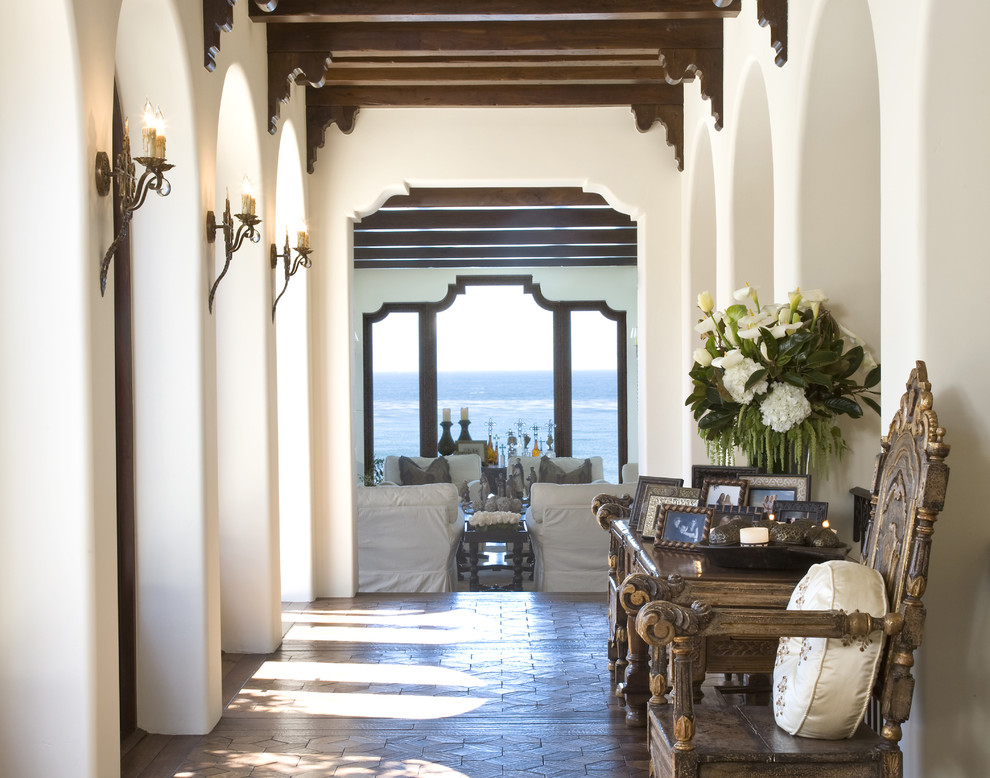 Inspiration for a large mediterranean hallway in San Diego with white walls, dark hardwood floors and brown floor.