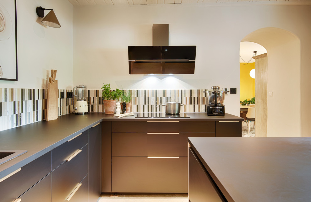 Photo of a medium sized eclectic u-shaped enclosed kitchen in Montpellier with black cabinets, an island and black worktops.