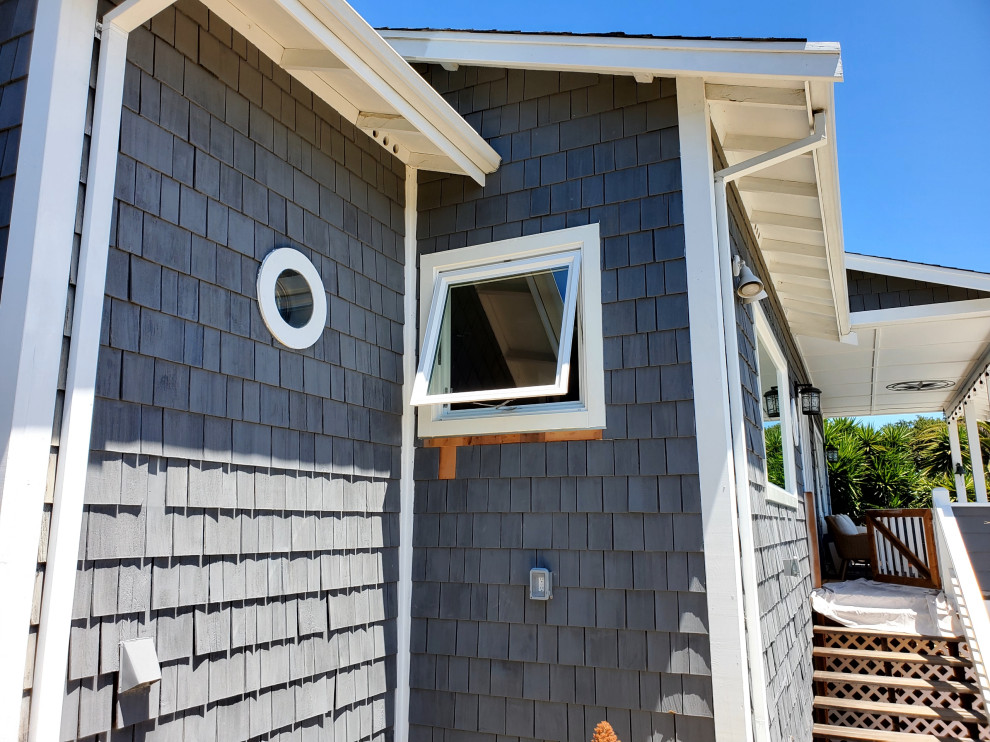 Стильный дизайн: маленький, одноэтажный, деревянный, синий частный загородный дом в морском стиле с отделкой дранкой для на участке и в саду - последний тренд