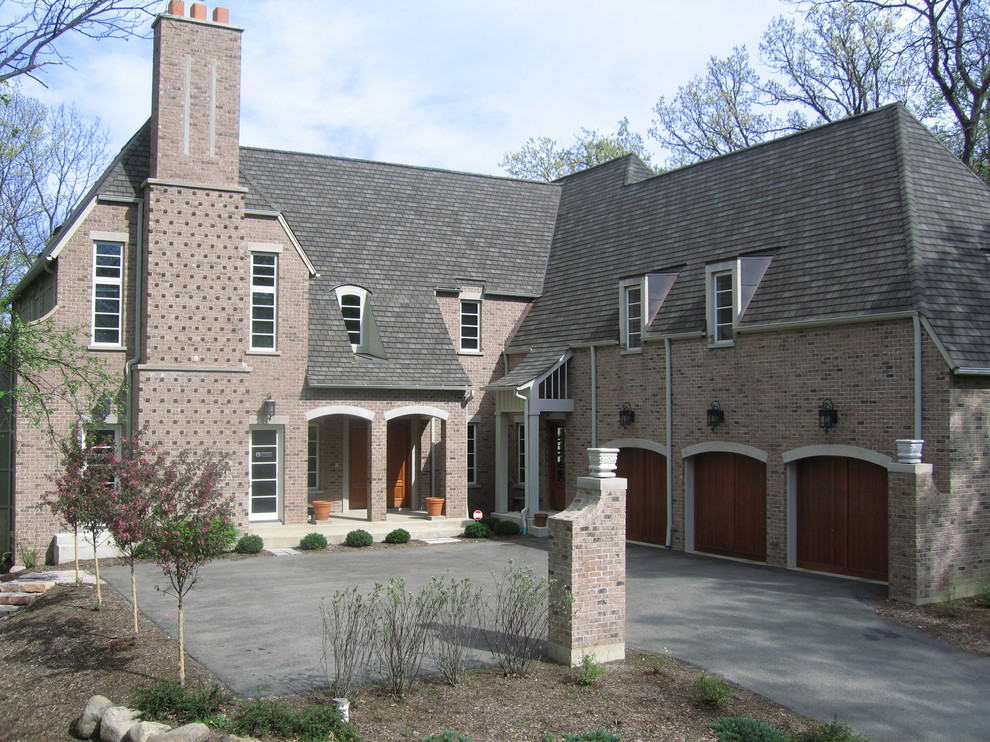 Large traditional two-storey brick beige house exterior in Chicago with a hip roof and a tile roof.