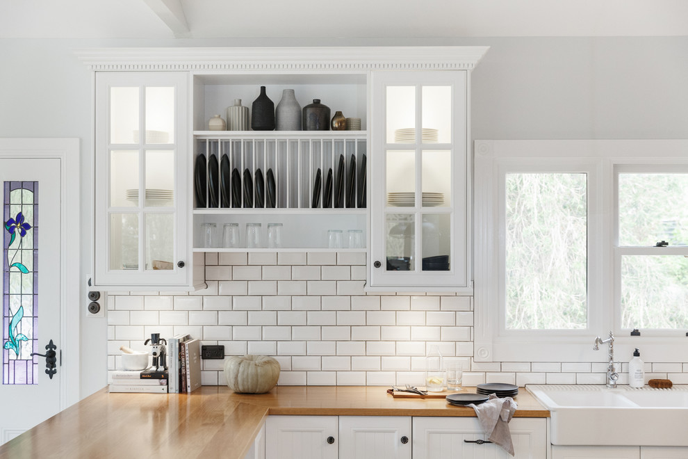 Design ideas for a large transitional u-shaped open plan kitchen in Adelaide with a farmhouse sink, shaker cabinets, green cabinets, wood benchtops, white splashback, subway tile splashback, stainless steel appliances, medium hardwood floors and multiple islands.