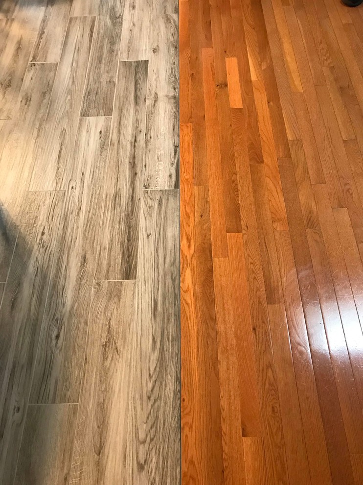 Example of a mid-sized transitional l-shaped porcelain tile and gray floor open concept kitchen design in Boston with a single-bowl sink, flat-panel cabinets, white cabinets, quartz countertops, gray backsplash, subway tile backsplash, stainless steel appliances, an island and white countertops