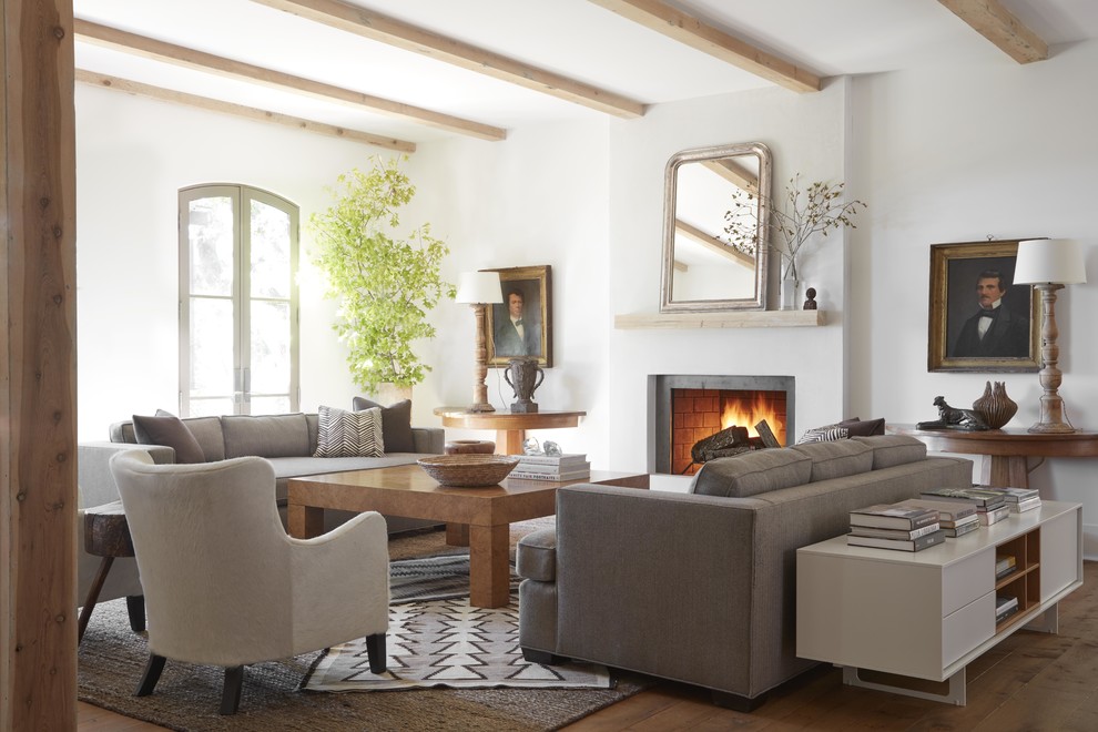 Design ideas for a beach style open concept living room in San Francisco with a library, white walls, a standard fireplace, a concrete fireplace surround and no tv.