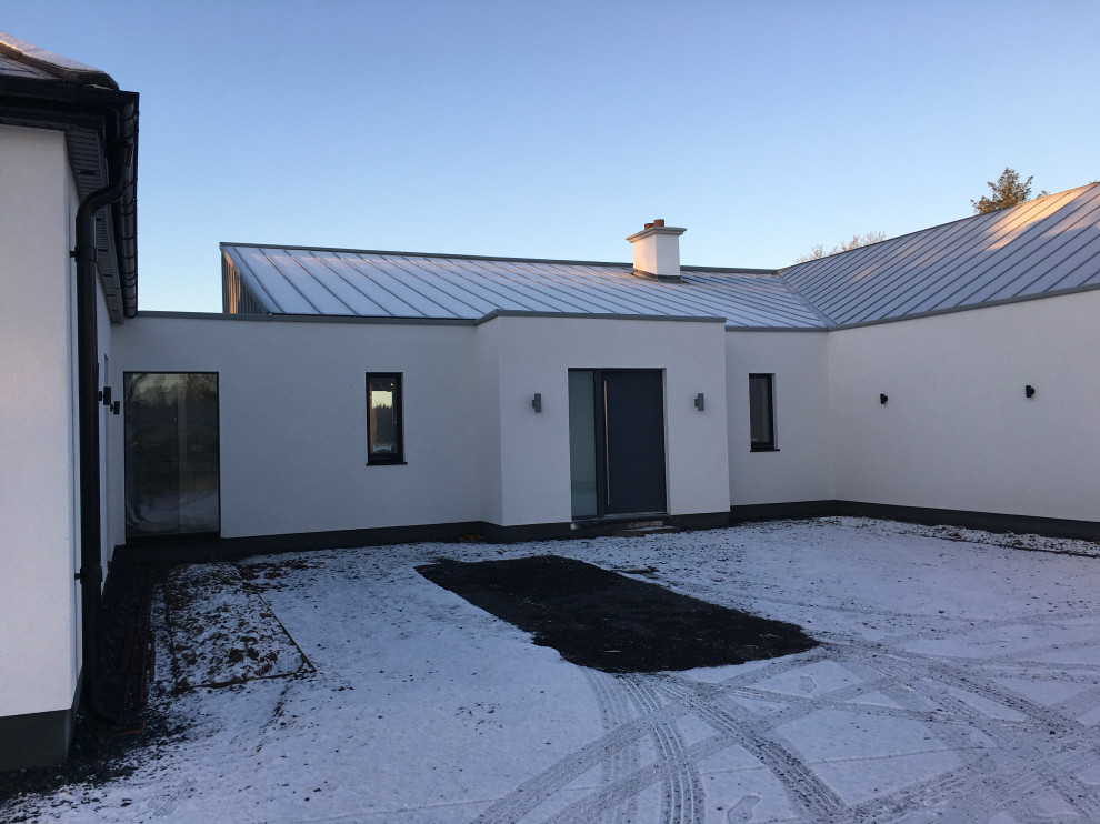 Foto de fachada de casa blanca y gris contemporánea de tamaño medio de una planta con revestimiento de estuco, tejado de un solo tendido, tejado de metal y panel y listón