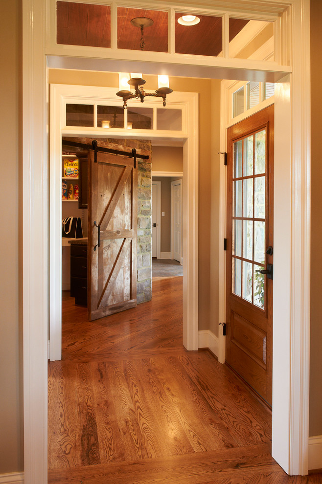 Expansive country foyer in Other with beige walls, medium hardwood floors, a single front door and a medium wood front door.