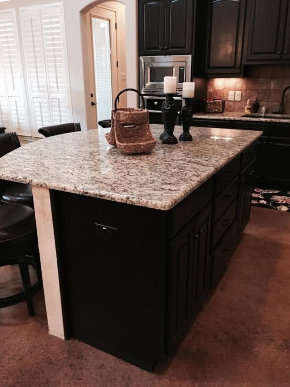 Eat-in kitchen - mid-sized rustic l-shaped concrete floor eat-in kitchen idea in Austin with an undermount sink, raised-panel cabinets, black cabinets, granite countertops, beige backsplash, ceramic backsplash, stainless steel appliances and an island