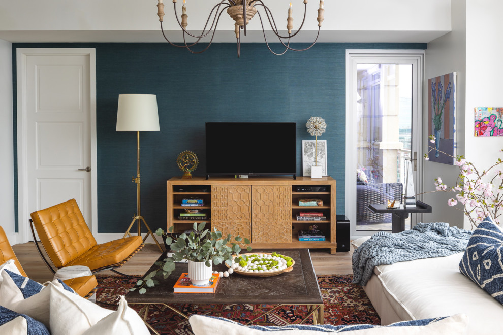 Imagen de sala de estar cerrada actual de tamaño medio sin chimenea con paredes multicolor, suelo de madera clara y televisor independiente