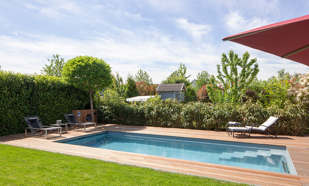 Mittelgroßes Mediterranes Sportbecken neben dem Haus in rechteckiger Form mit Wasserspiel und Dielen in Düsseldorf