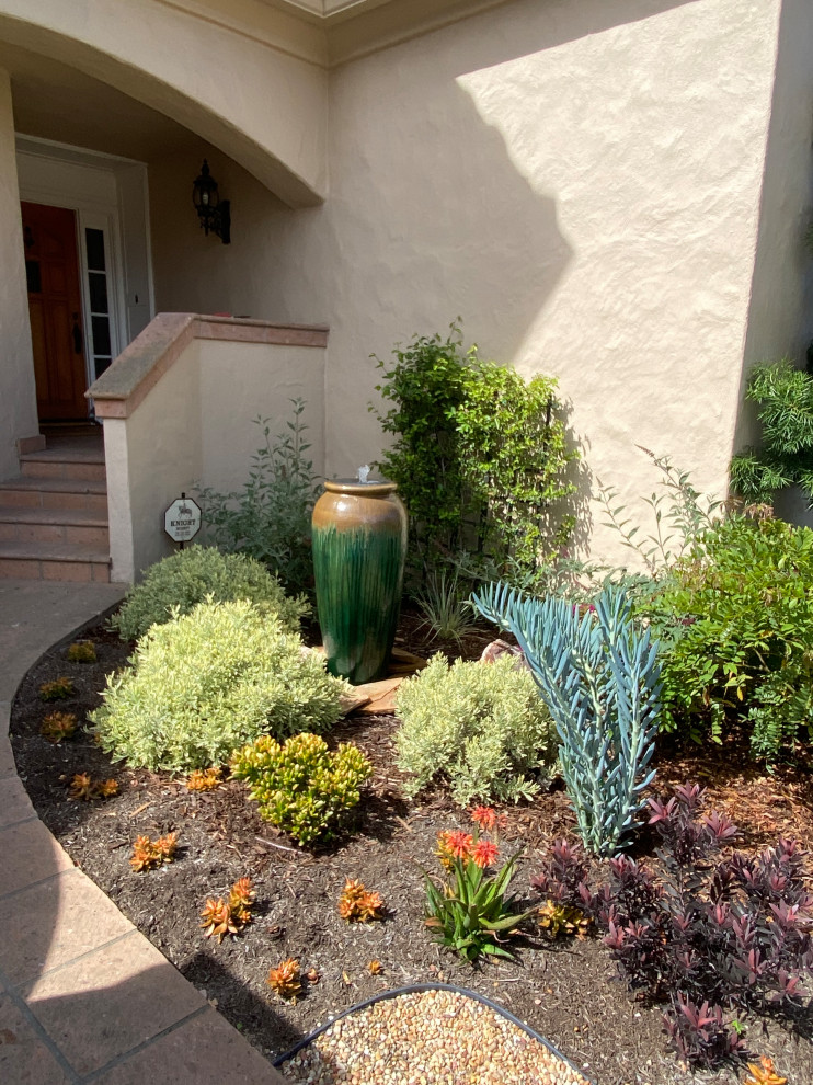 Стильный дизайн: маленький засухоустойчивый сад на переднем дворе в средиземноморском стиле с полуденной тенью и покрытием из гравия для на участке и в саду - последний тренд