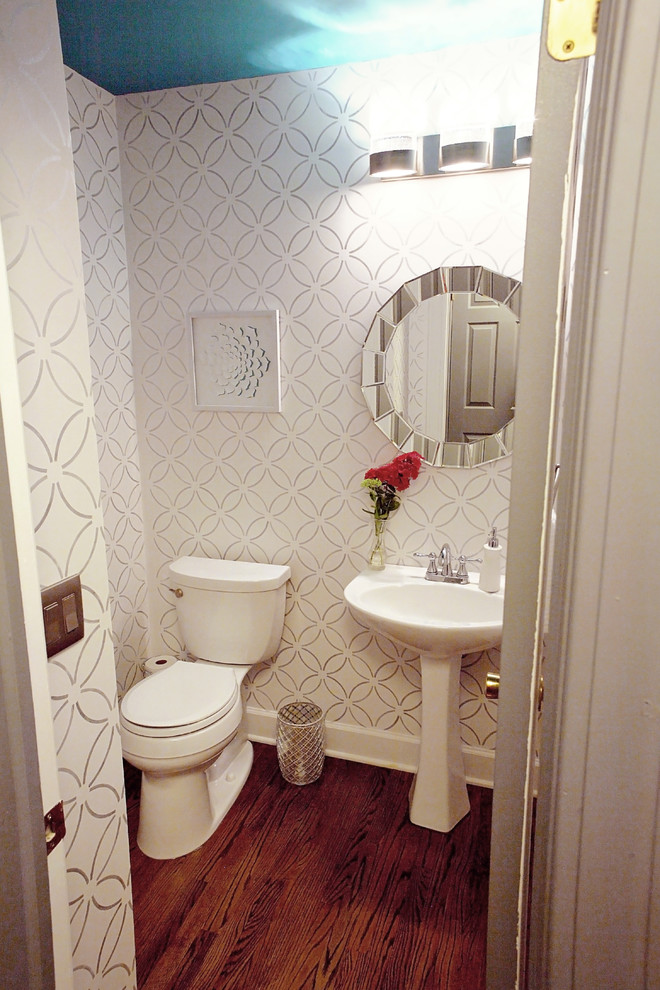 This is an example of a small modern bathroom in Boston with a pedestal sink, a two-piece toilet, white walls and medium hardwood floors.