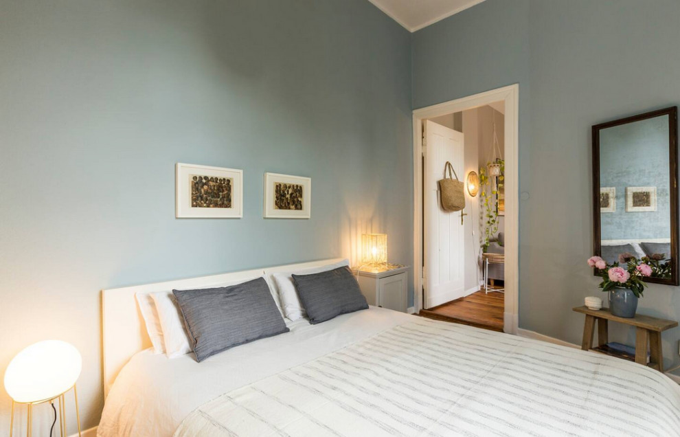 Immagine di una camera matrimoniale scandinava di medie dimensioni con parquet chiaro, pareti beige e pareti in mattoni