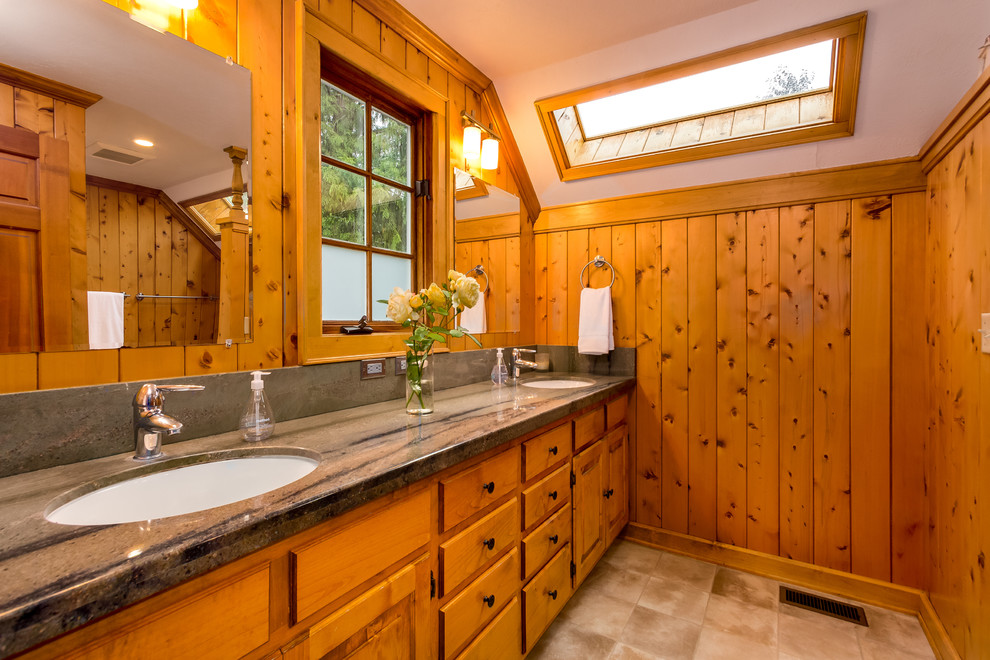 Photo of a large country master bathroom in Seattle with raised-panel cabinets, medium wood cabinets, porcelain floors, an undermount sink and granite benchtops.