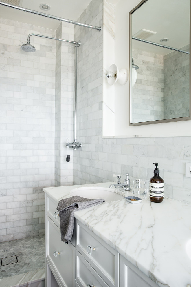Inspiration for a large transitional master bathroom in New York with an undermount sink, white cabinets, marble benchtops, an alcove shower, white tile, white walls, open cabinets, a drop-in tub, a one-piece toilet, subway tile and ceramic floors.