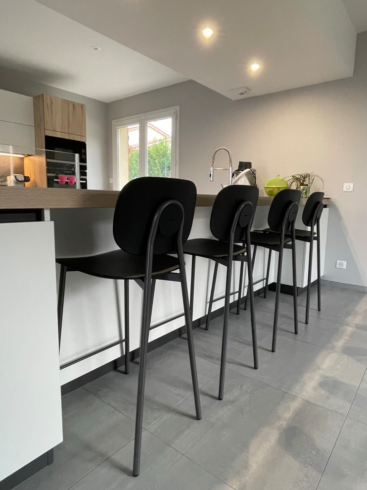 Photo of a large contemporary galley kitchen in Lyon with laminate benchtops, grey splashback, with island and grey benchtop.