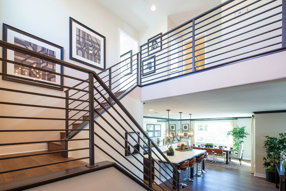 This is an example of a mid-sized contemporary wood u-shaped staircase in Los Angeles with wood risers and metal railing.