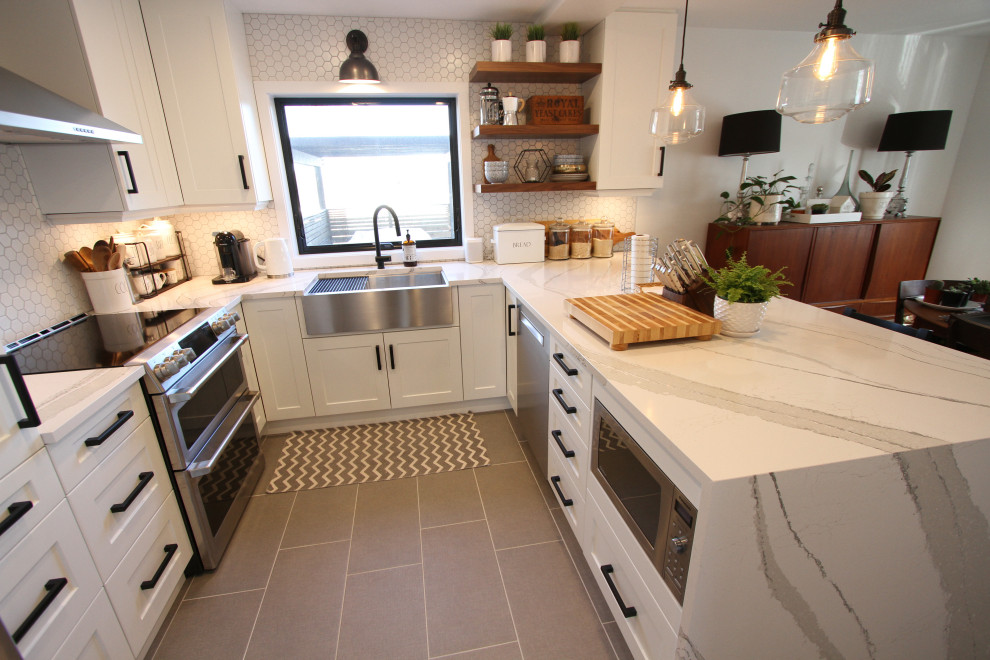 Photo of a small classic u-shaped kitchen/diner in Toronto with a belfast sink, shaker cabinets, white cabinets, engineered stone countertops, white splashback, mosaic tiled splashback, stainless steel appliances, porcelain flooring, a breakfast bar, grey floors and white worktops.