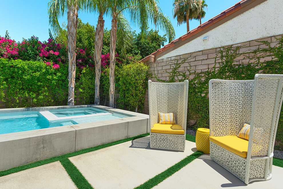Small midcentury backyard rectangular pool in Los Angeles with a water feature and concrete slab.