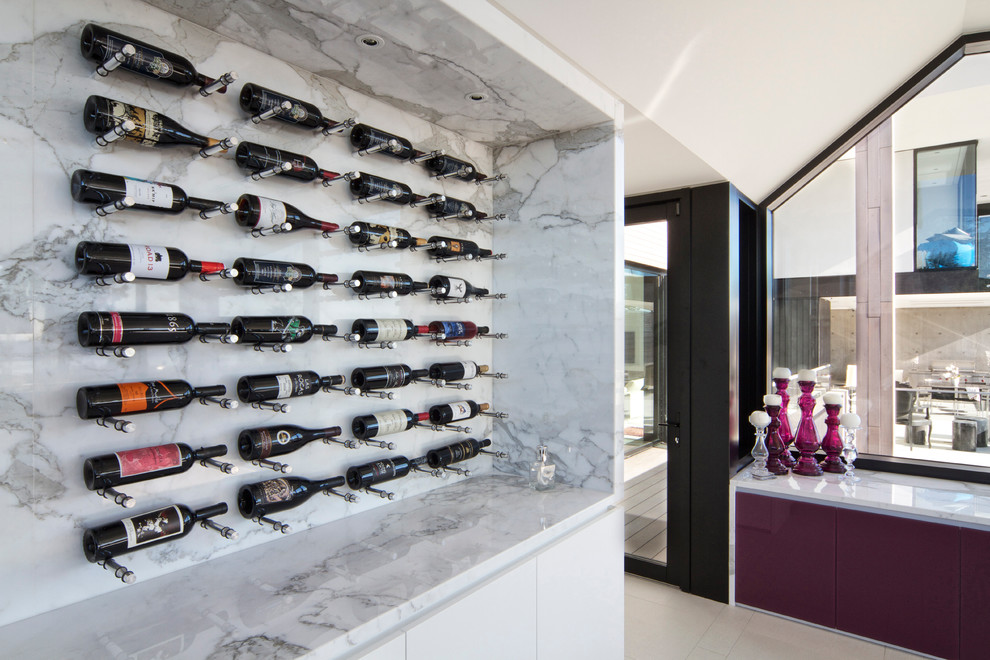 This is an example of a mid-sized modern wine cellar in Vancouver with display racks.