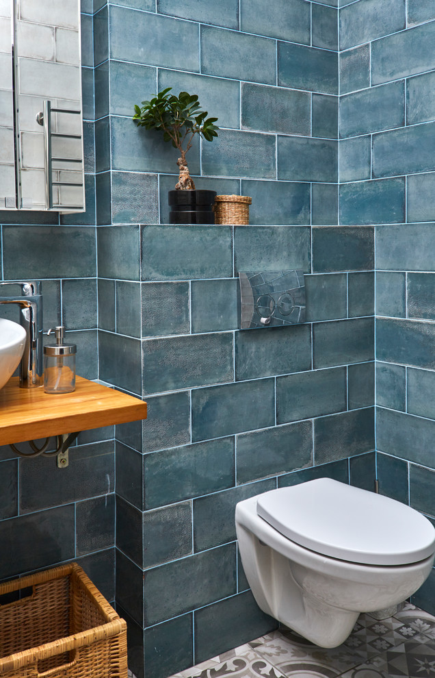 Design ideas for a contemporary powder room in Other with green tile and a wall-mount sink.