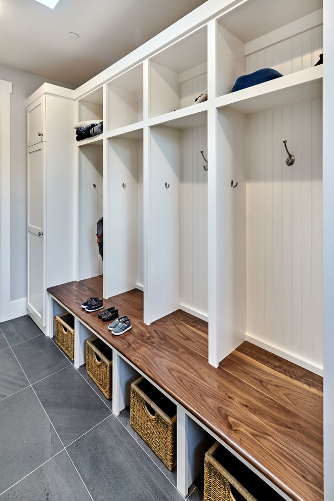 This is an example of a mid-sized transitional galley utility room in San Francisco with an undermount sink, shaker cabinets, white cabinets, quartz benchtops, grey walls, porcelain floors and a side-by-side washer and dryer.
