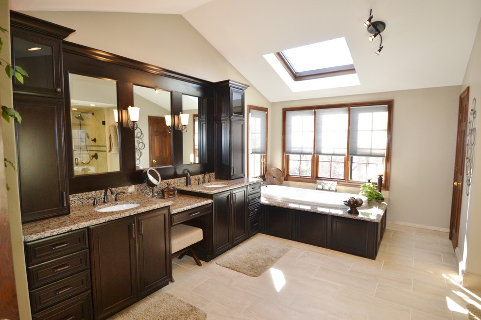 Design ideas for a large traditional master bathroom in Columbus with recessed-panel cabinets, dark wood cabinets, granite benchtops, beige tile and porcelain tile.