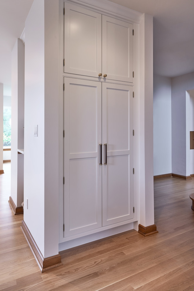 Example of a mid-sized transitional u-shaped medium tone wood floor kitchen design in Seattle with a farmhouse sink, beaded inset cabinets, white cabinets, quartz countertops, green backsplash, porcelain backsplash, stainless steel appliances, an island and white countertops