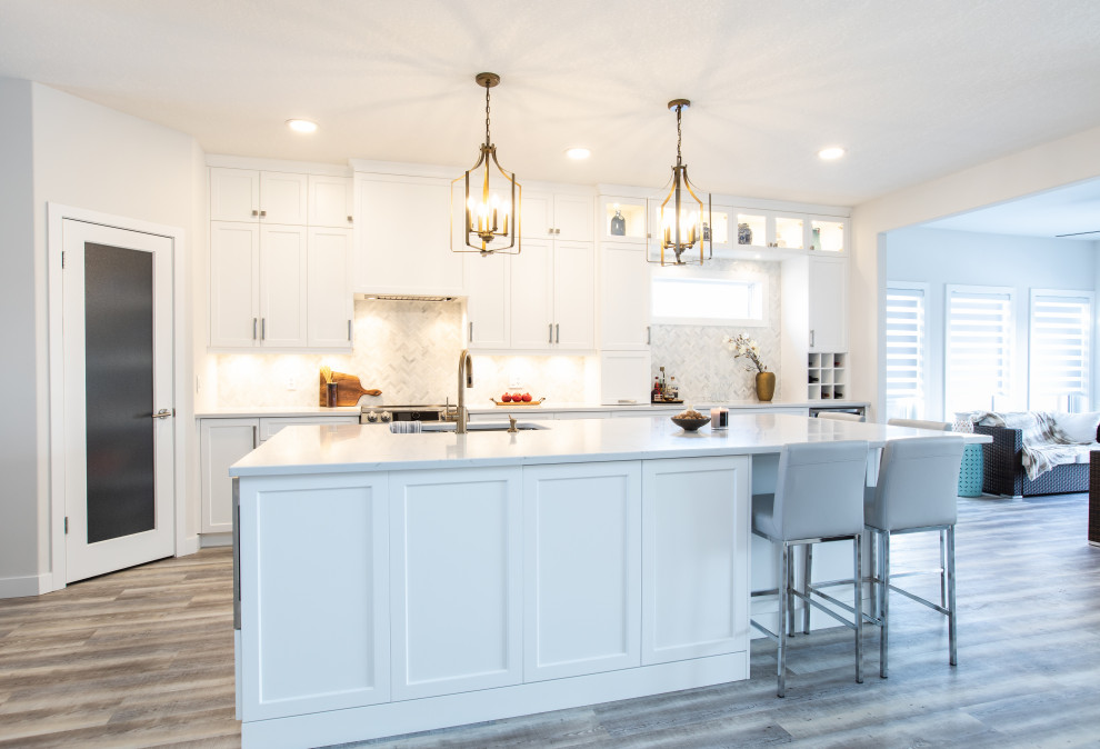 Example of a large transitional l-shaped vinyl floor and gray floor open concept kitchen design with an undermount sink, shaker cabinets, white cabinets, quartz countertops, white backsplash, marble backsplash, stainless steel appliances, an island and white countertops