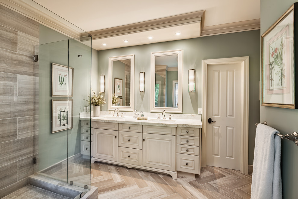 This is an example of a traditional bathroom in Other with raised-panel cabinets, a corner shower, gray tile, travertine, an undermount sink, onyx benchtops, a hinged shower door, white benchtops, beige cabinets, green walls and beige floor.