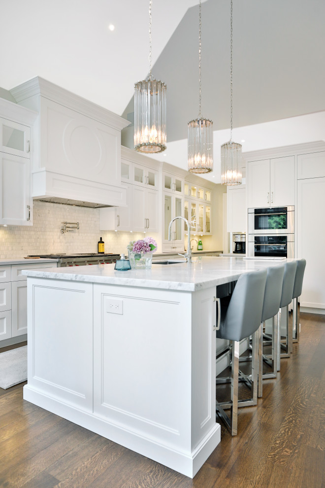 Kitchen pantry - large transitional l-shaped medium tone wood floor and brown floor kitchen pantry idea in Toronto with an undermount sink, shaker cabinets, white cabinets, quartz countertops, white backsplash, marble backsplash, paneled appliances, an island and white countertops