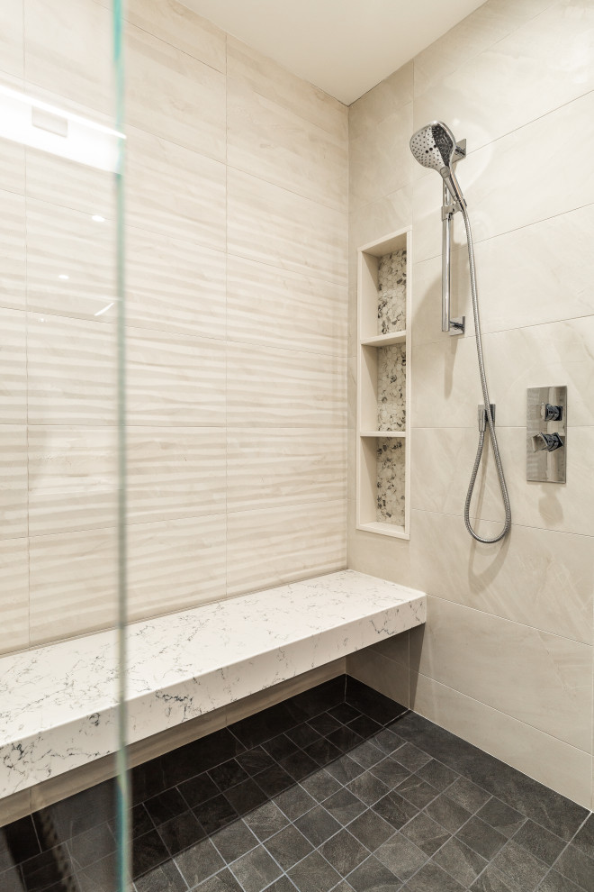 This is an example of a mid-sized contemporary master bathroom in Montreal with flat-panel cabinets, medium wood cabinets, a drop-in tub, a double shower, a wall-mount toilet, beige tile, slate, beige walls, slate floors, an undermount sink, engineered quartz benchtops, grey floor, a hinged shower door, white benchtops, a shower seat, a double vanity, a built-in vanity and wood walls.