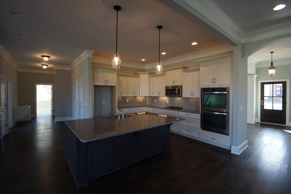 Large transitional l-shaped dark wood floor open concept kitchen photo in Nashville with shaker cabinets, white cabinets, granite countertops, gray backsplash, stainless steel appliances and an island