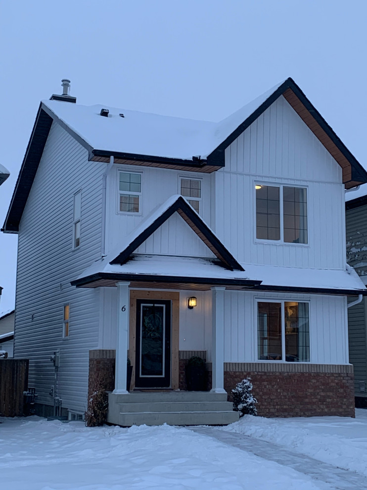 Photo of a white modern two floor detached house in Calgary with vinyl cladding, a shingle roof and a black roof.