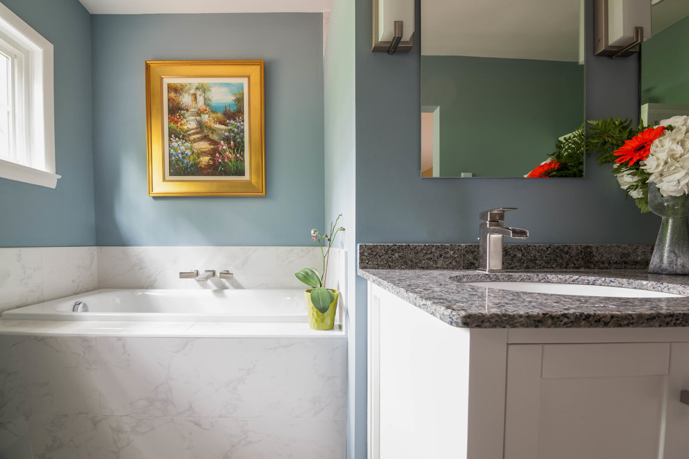 Example of a large transitional master white tile and ceramic tile ceramic tile and beige floor drop-in bathtub design in Atlanta with shaker cabinets, white cabinets, a one-piece toilet, blue walls, an undermount sink and granite countertops