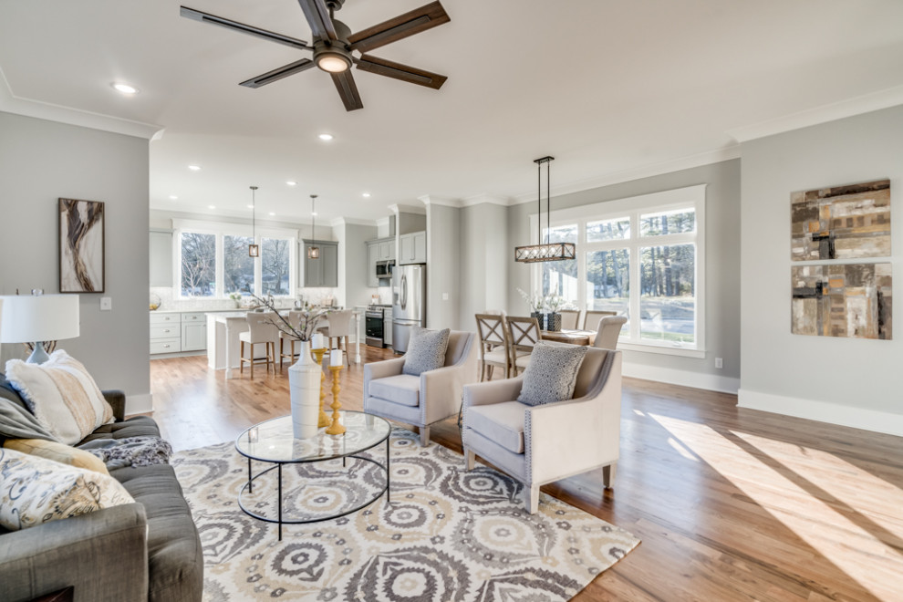 Design ideas for a mid-sized country open concept family room in Raleigh with grey walls, light hardwood floors, no fireplace and a wall-mounted tv.