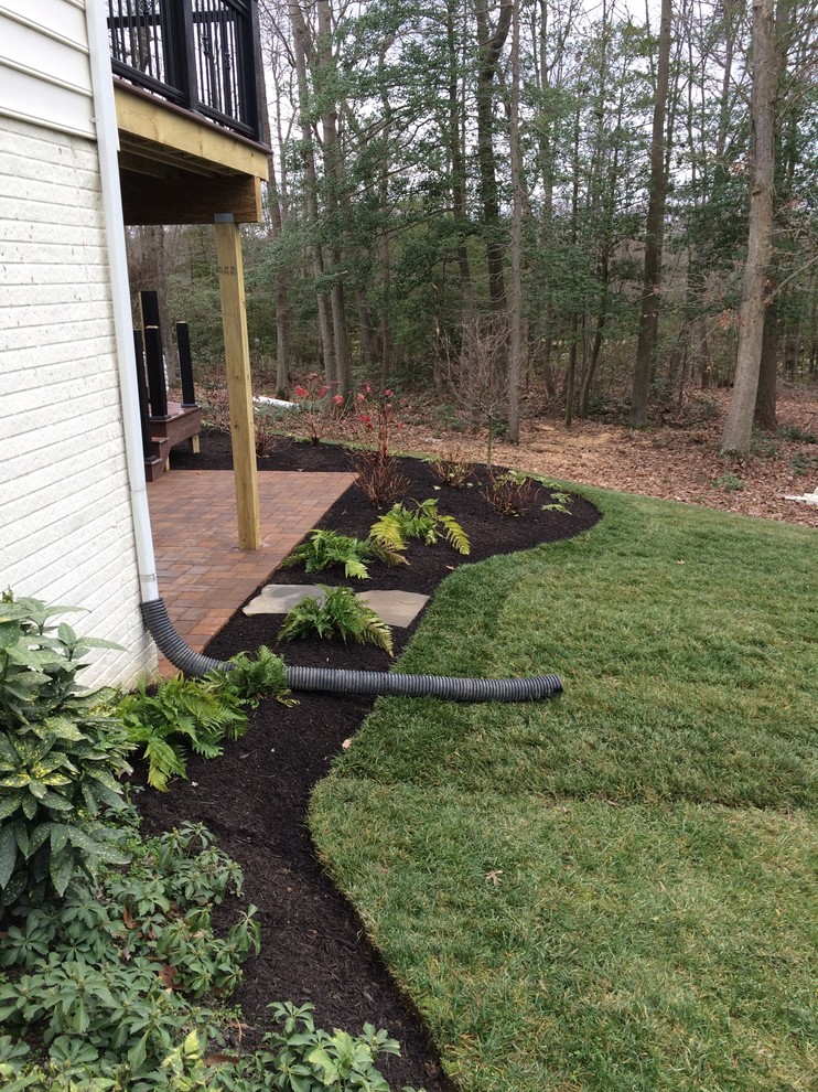 Example of a large minimalist backyard concrete paver partial sun home design design for fall in Baltimore with a fire pit