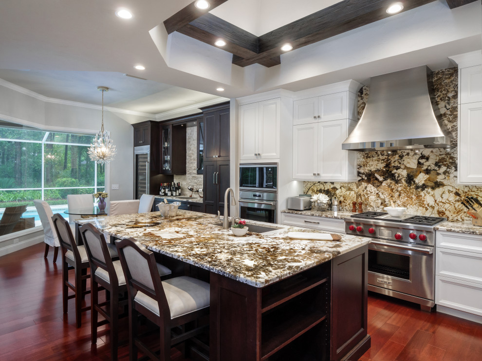 Exempel på ett stort klassiskt flerfärgad flerfärgat kök, med en undermonterad diskho, släta luckor, vita skåp, bänkskiva i kvartsit, flerfärgad stänkskydd, stänkskydd i sten, rostfria vitvaror, mellanmörkt trägolv, en köksö och brunt golv